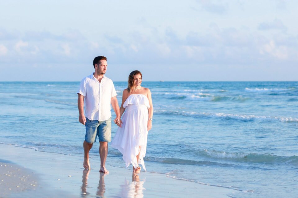 Photo of parents to be on the Naples beach by Katrina Photography