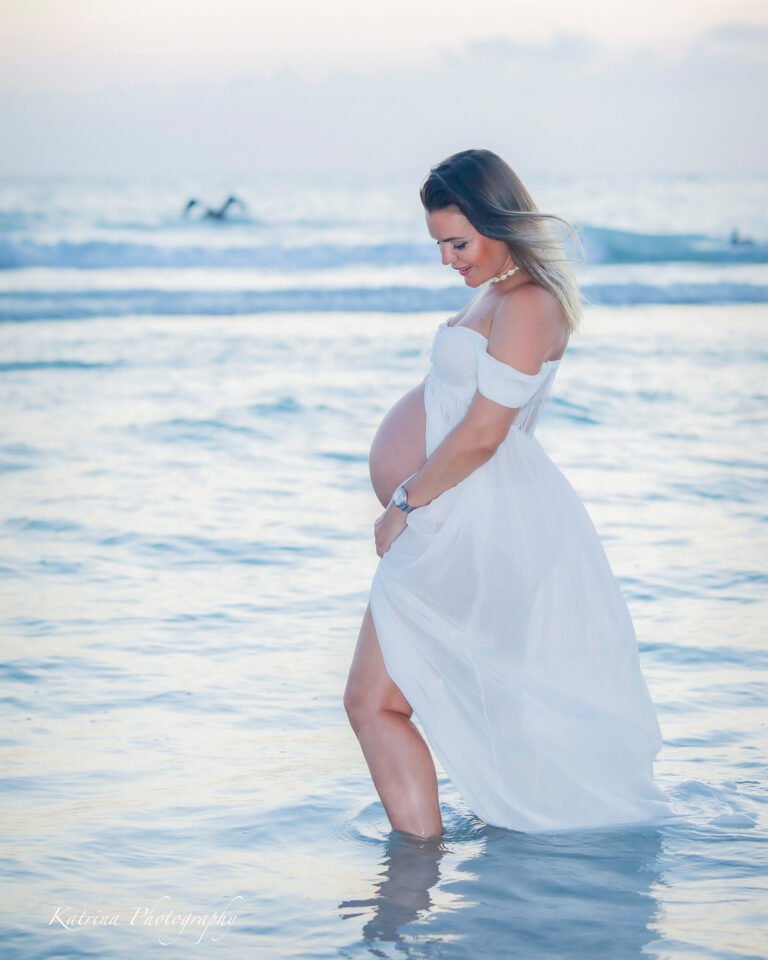 Photo of a mom to be on the Naples beach by Katrina Photography